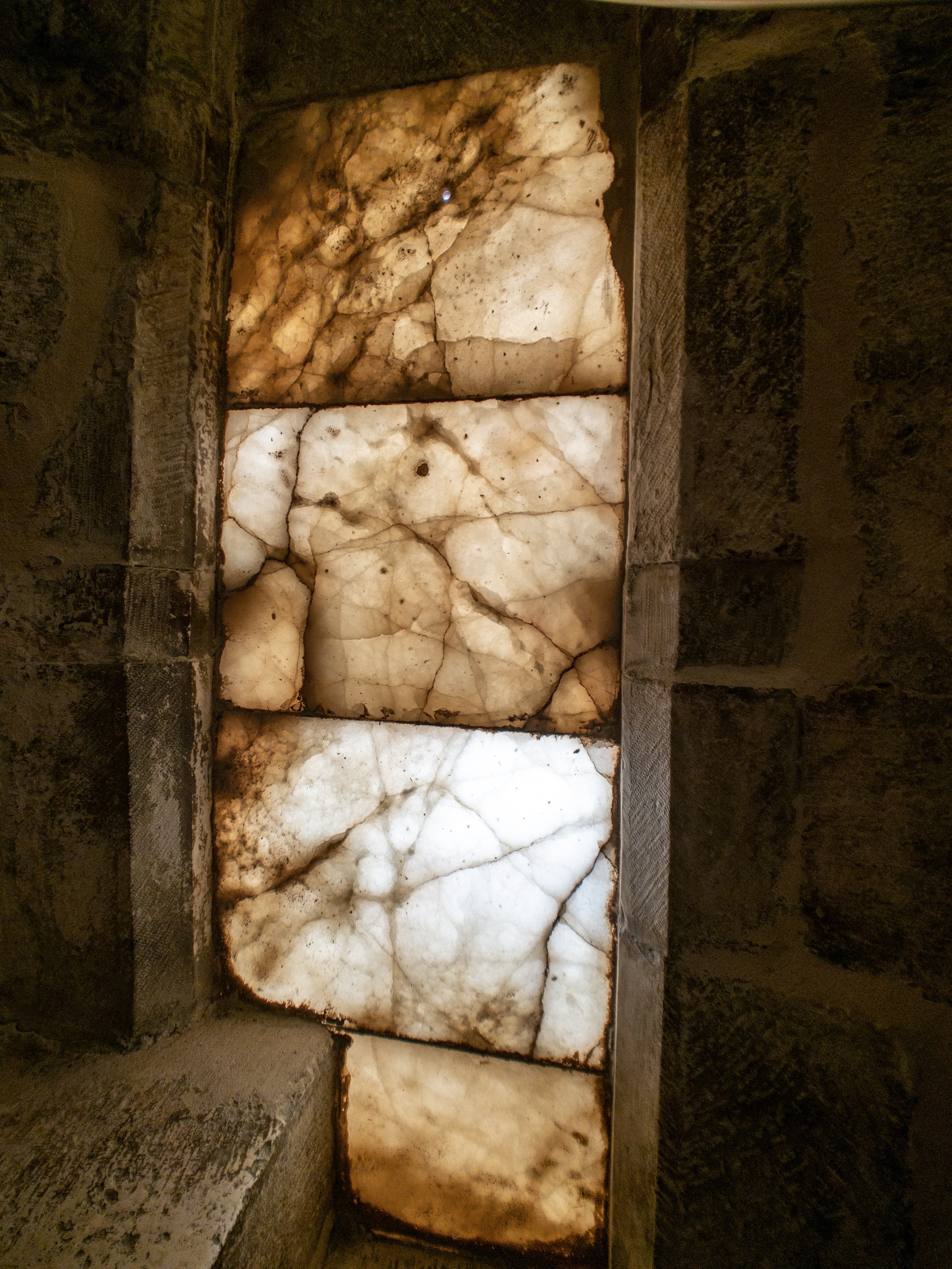 A thin slab of marble lets light into the narrow, dark spiral stairs to the roof