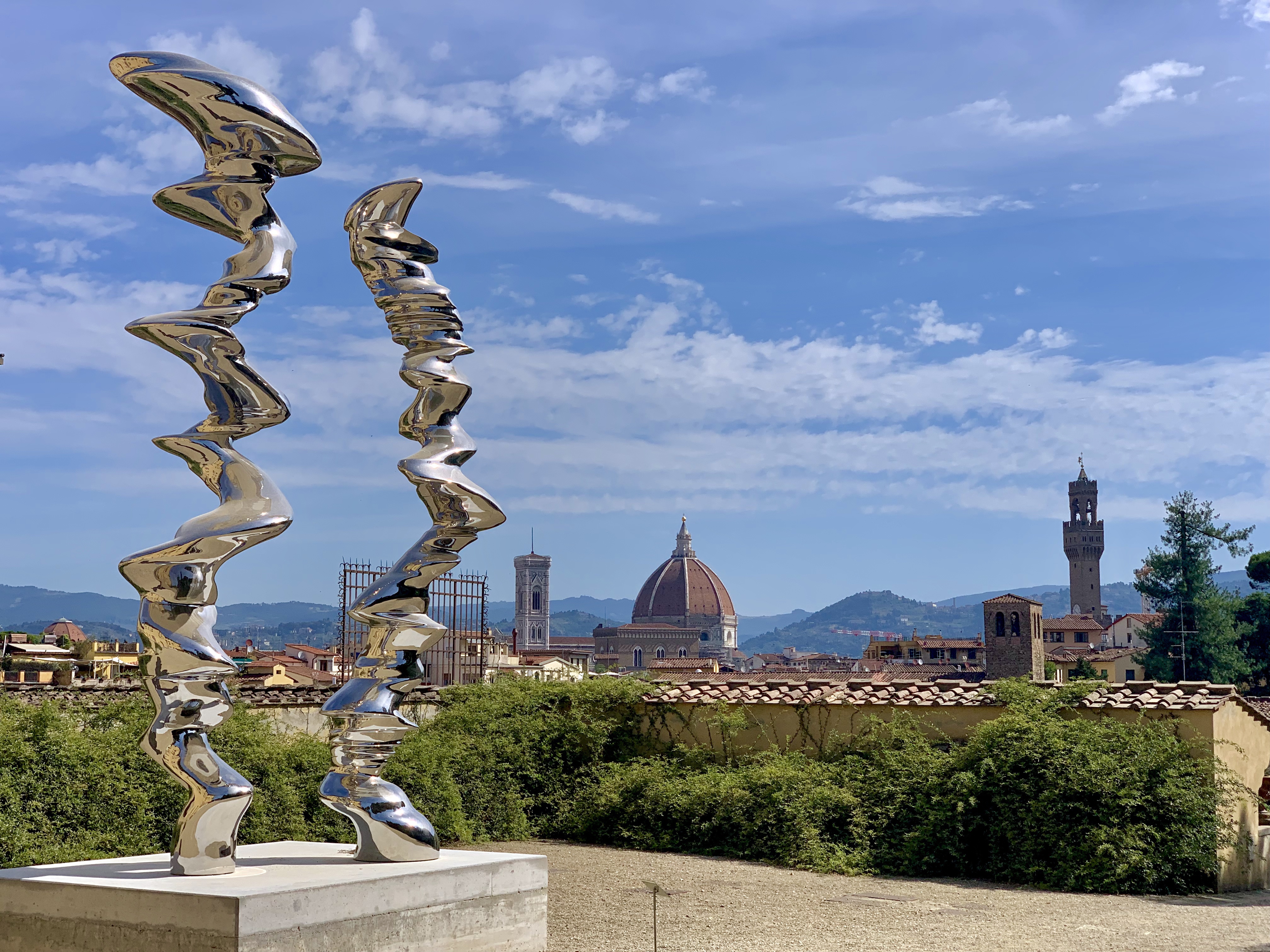 A piece of modern sculpture contrasts with the Florence skyline from Boboli Gardens